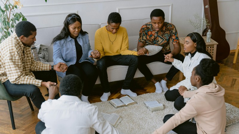 A group of people holding hands in prayer, creating a sense of unity., tags: junge glauben und - pexel